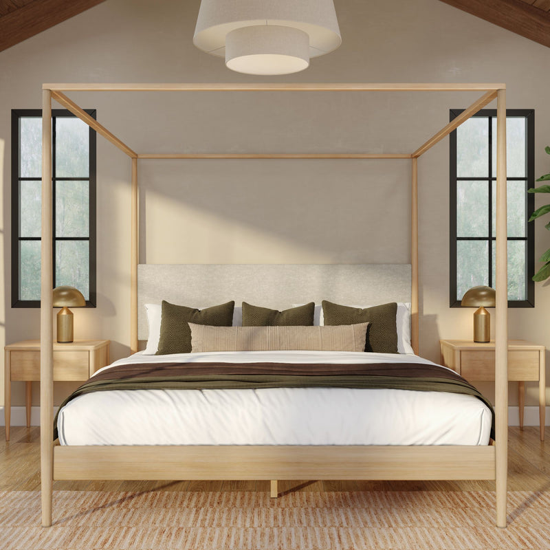 Modern minimalist bedroom with light wood four-poster canopy bed, neutral bedding, green accent pillows and matching nightstands