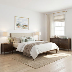 Neutral modern bedroom with upholstered wood bedframe, neutral bedding, light hardwood floors, natural fiber rug, brass lamps, dresser and roman shade window