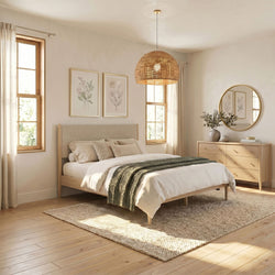 Sunlit neutral bedroom with wood bed frame, green throw, boho rattan pendant light, round mirror dresser, botanical wall art