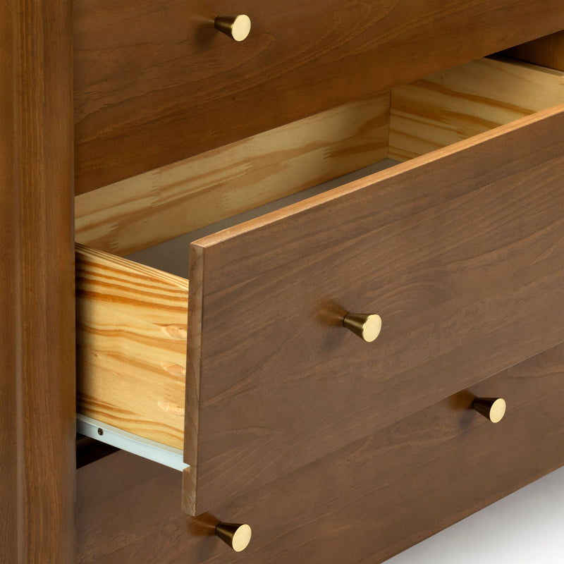Close-up of open solid wood dresser drawers with walnut finish, pine interiors, and brass knob handles
