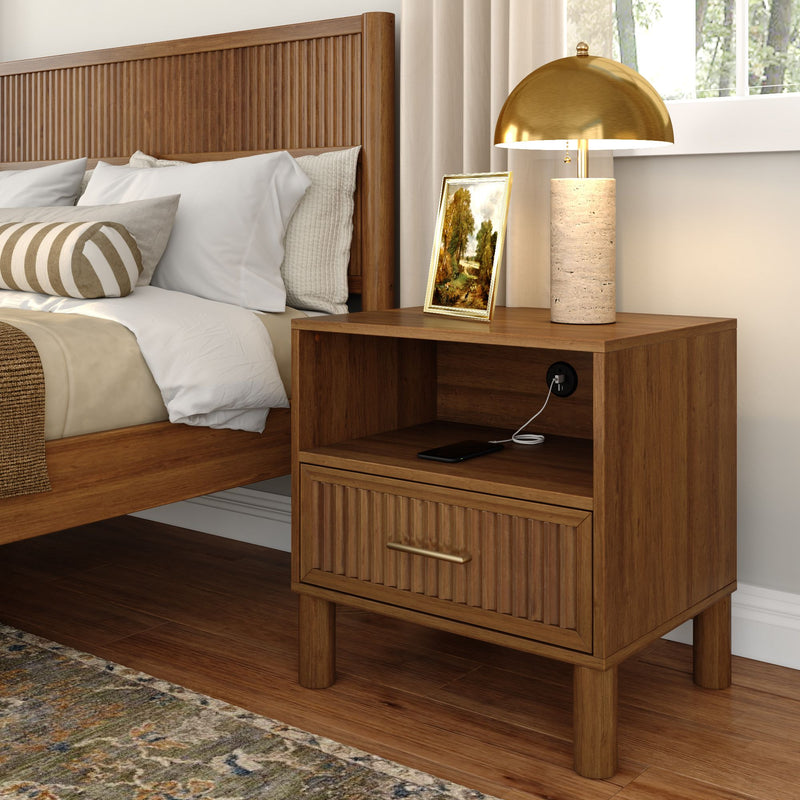 Modern cozy bedroom close-up with wooden slatted headboard, wooden nightstand with built-in charging port, brass dome lamp, framed art and neutral bedding