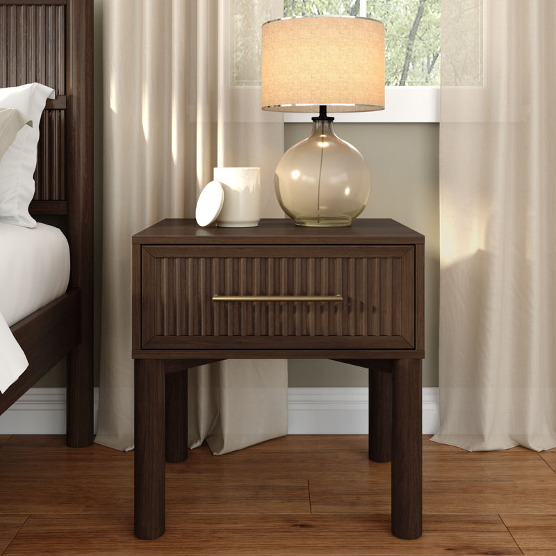 Modern dark wood nightstand with ribbed drawer, amber glass table lamp and beige curtains in a cozy minimalist bedroom