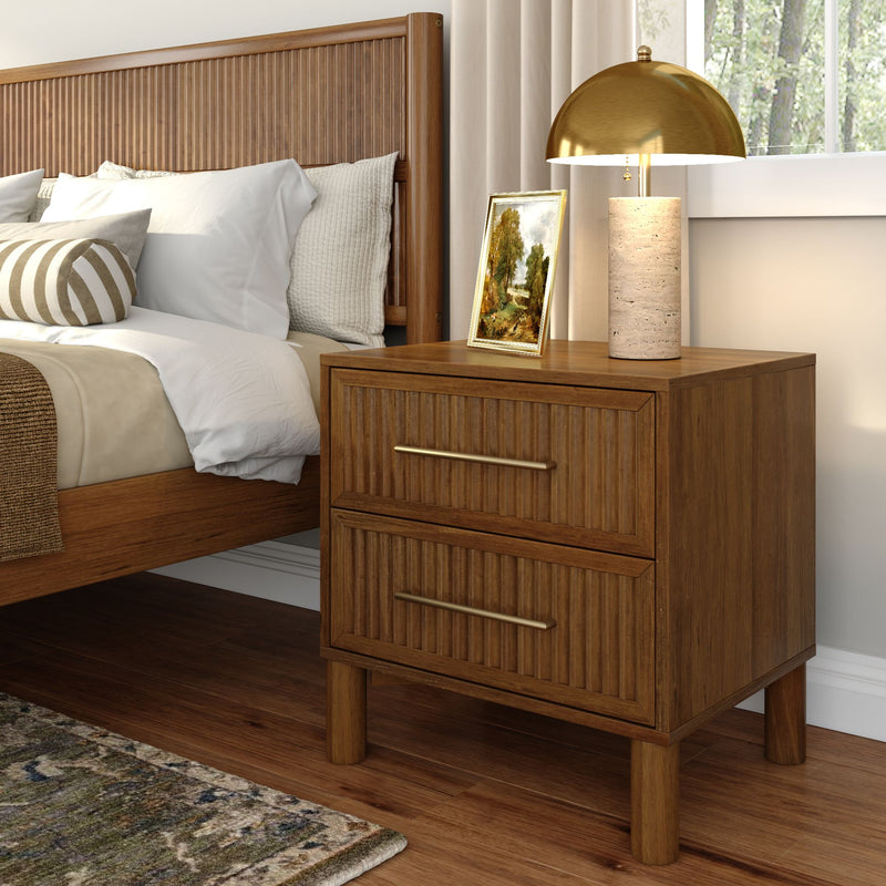 Mid-century modern bedroom with wooden fluted headboard, matching wood nightstand, brass dome table lamp, framed landscape art and neutral striped lumbar pillow