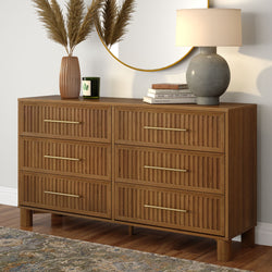 Mid-century modern six-drawer walnut dresser with brass handles, round wall mirror, ceramic lamp, decorative vase and books on hardwood floor