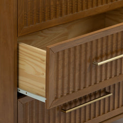 Mid-century modern wood dresser with fluted drawer fronts and brass bar handles, open drawer showing natural pine interior and metal drawer slides