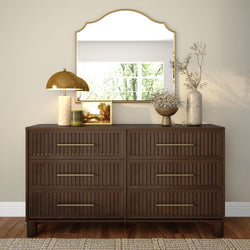 Dark wood six-drawer dresser with gold-framed mirror, brass lamp, framed picture and ceramic vases styled for neutral entryway or bedroom decor