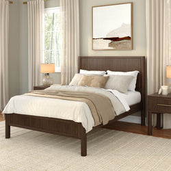 Cozy modern farmhouse bedroom with dark wood bed frame, neutral beige linen bedding, floor-to-ceiling curtains, wooden nightstand with glass lamp, abstract framed wall art and woven rug