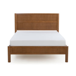 Natural wood bed frame with ribbed-panel headboard and footboard and white mattress on white background, modern bedroom furniture