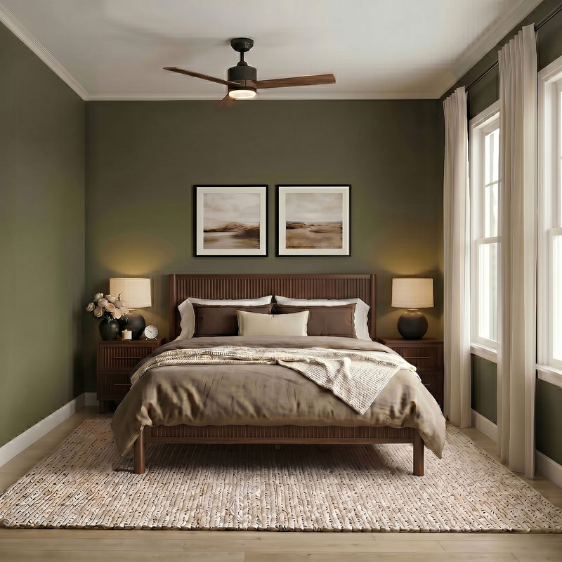 Modern cozy bedroom with olive-green walls, wooden platform bed, neutral bedding, woven area rug, ceiling fan, bedside lamps and framed wall art