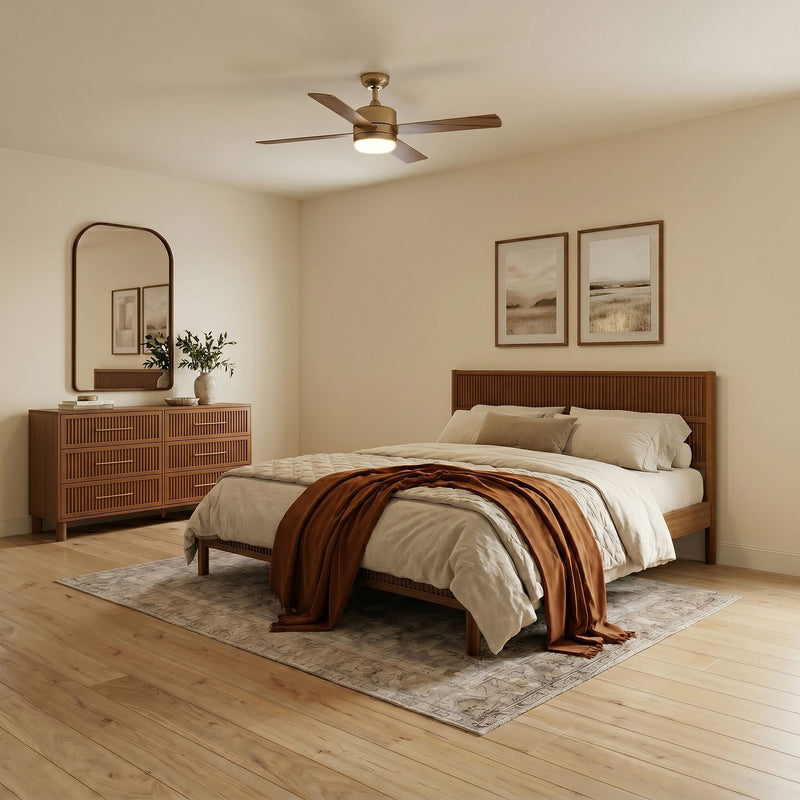 Modern minimalist bedroom with wooden platform bed, beige bedding and rust throw, wooden dresser and mirror, ceiling fan and hardwood floors