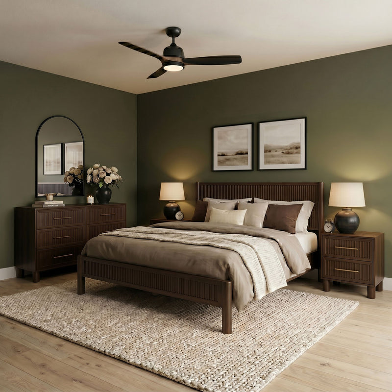 Modern bedroom with wooden bed frame, ceiling fan with integrated light, matching nightstands and dresser, neutral bedding and woven rug on olive‑green walls