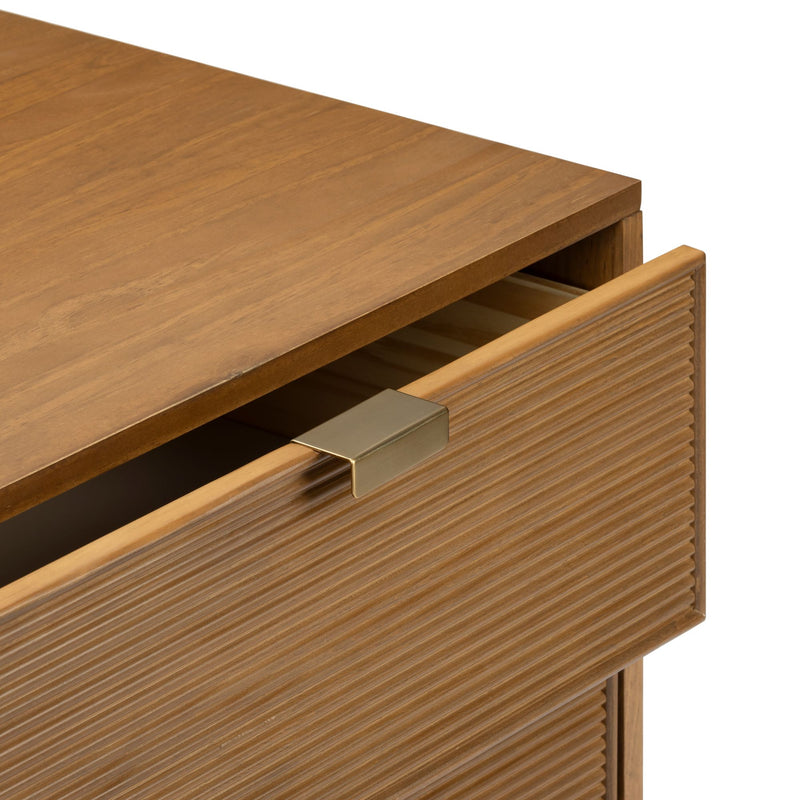 Mid-century modern wooden dresser drawer close-up showing ribbed walnut front, warm wood grain and matte brass pull handle