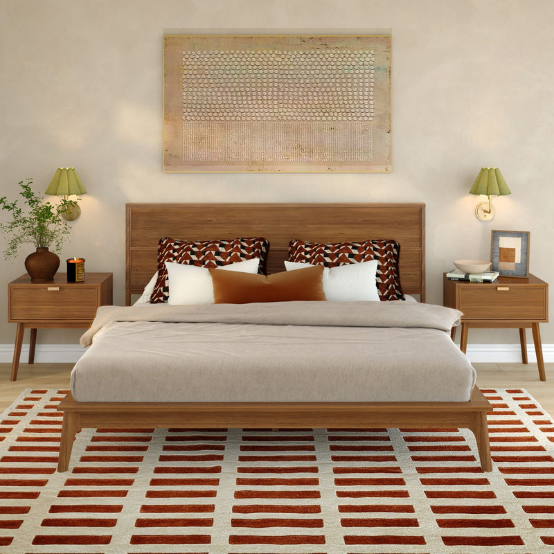 Mid-century modern bedroom with wood platform bed, neutral linen bedding, geometric throw pillows, matching wooden nightstands, green wall sconces, abstract wall art, potted plant and red-striped area rug