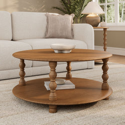 Round oak coffee table with a speckled ceramic bowl in a neutral modern living room featuring a textured beige sofa, linen throw pillow, wooden side table with lamp and indoor plant
