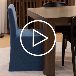 Video thumbnail: blue upholstered slipcovered dining chair beside dark wood rectangular dining table with black chairs on beige rug in modern dining room