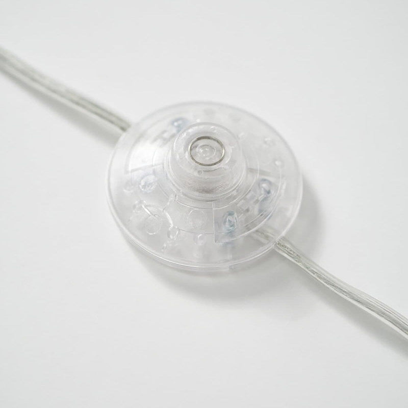 Clear plastic inline power switch on white background.