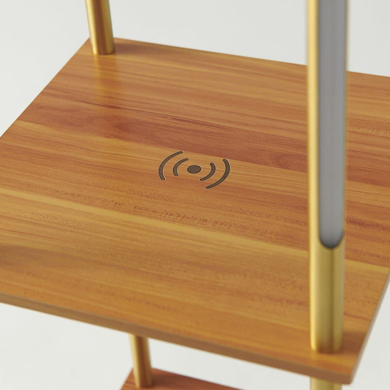 Modern wooden shelving unit with brass-finish metal posts and built-in Qi wireless phone charging pad engraved on top shelf