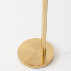 Gold floor lamp base on a white background, minimalist home decor design.