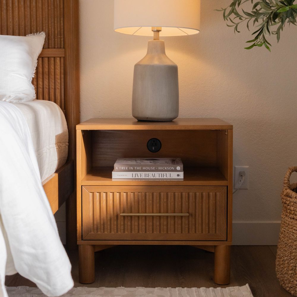 Decorative black console table with candles and wine, set against a wall with festive wreaths.
