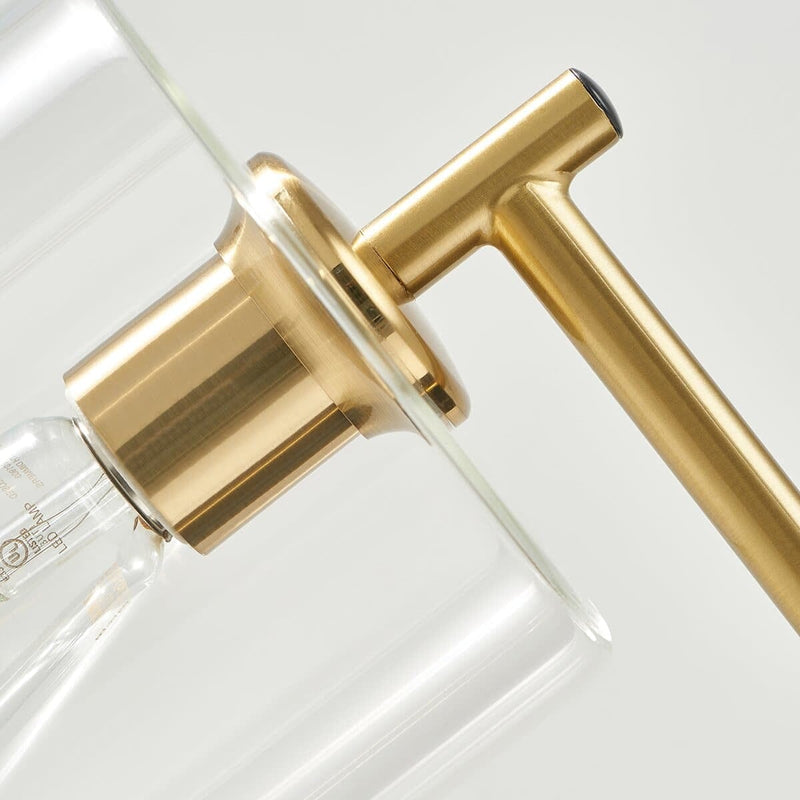 Close-up of a modern gold faucet with a sleek glass chamber design.