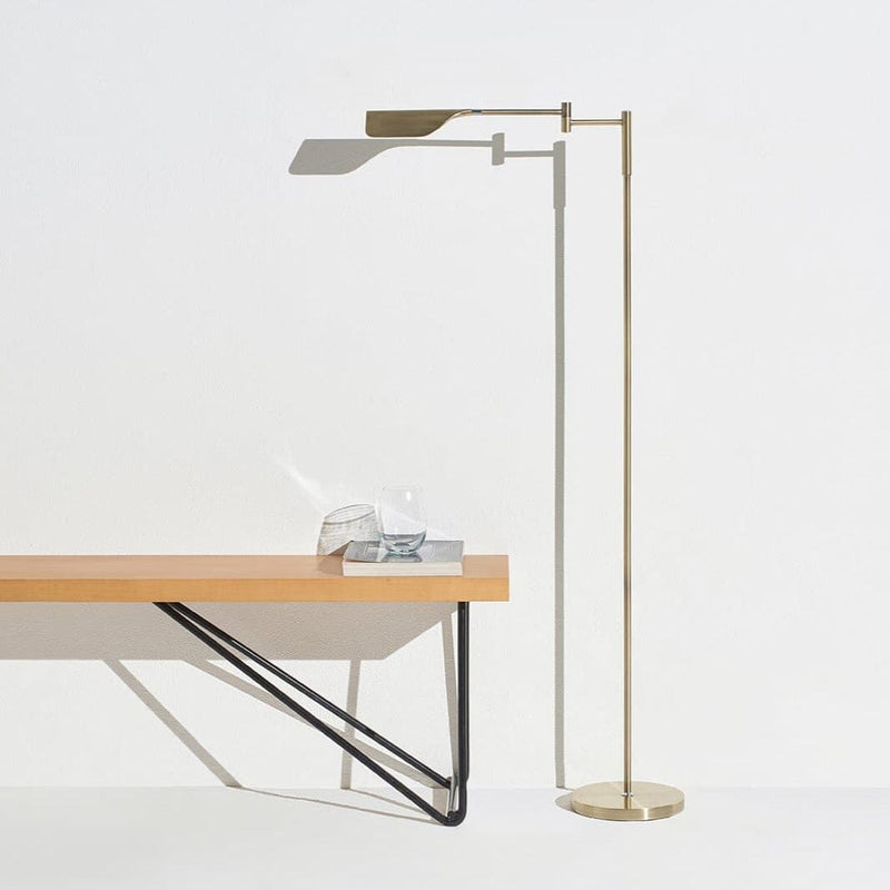 Modern minimalist floor lamp and wooden bench with glass decor in bright room.