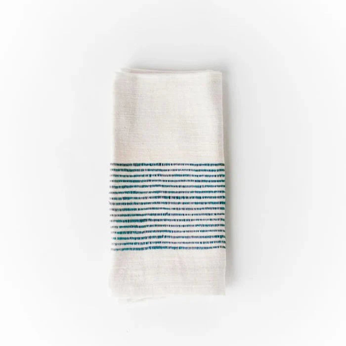 Folded white towel with blue stripe pattern on a white background.