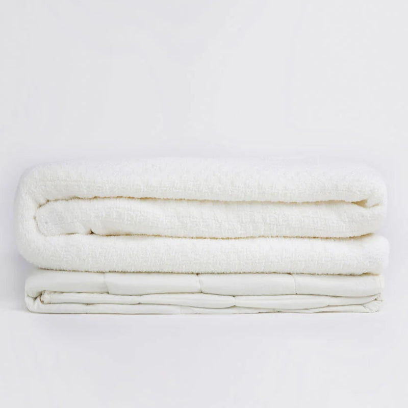 Folded white blanket on a white background, cozy and soft bedding solution.