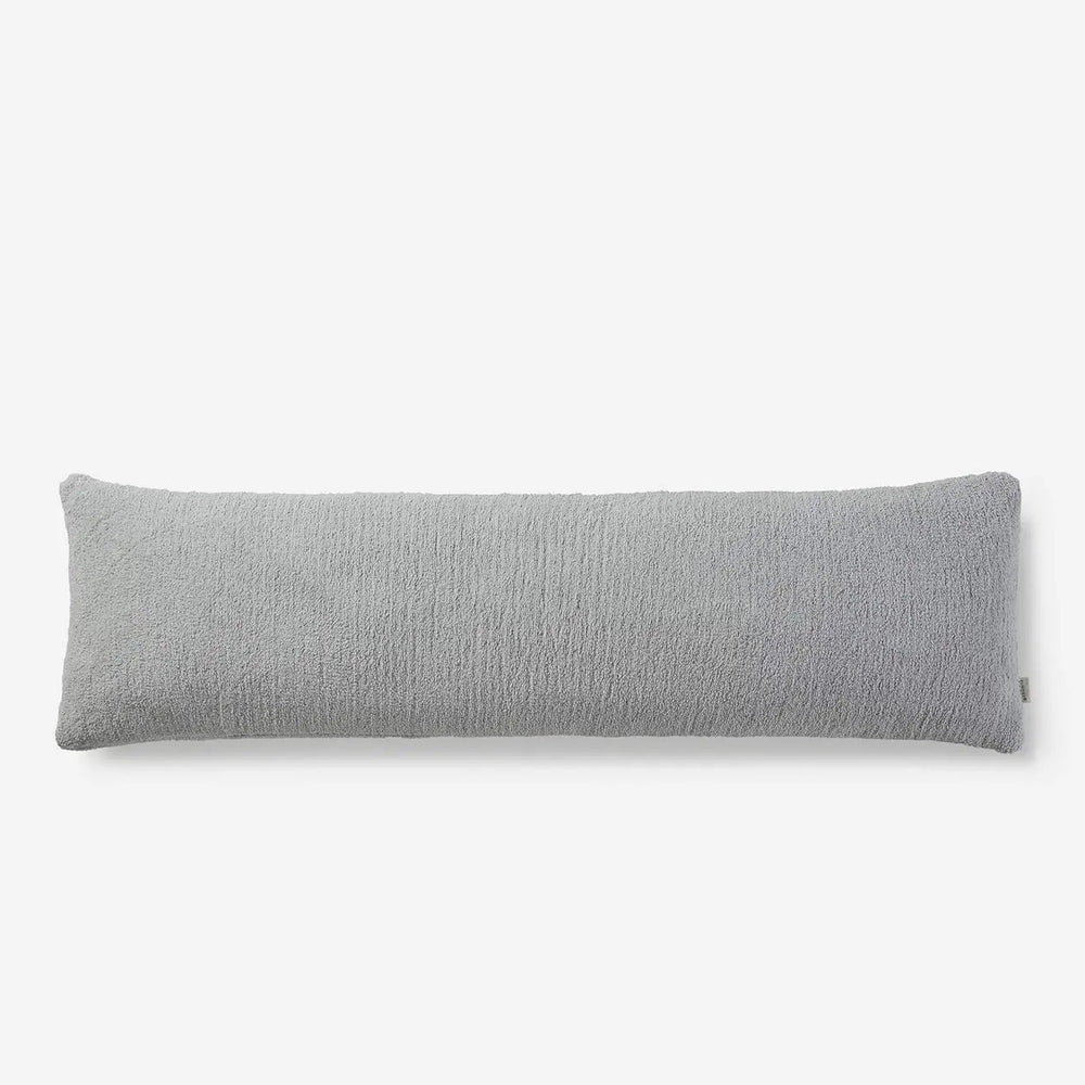 Gray body pillow with textured cover for comfortable and stylish bedding.