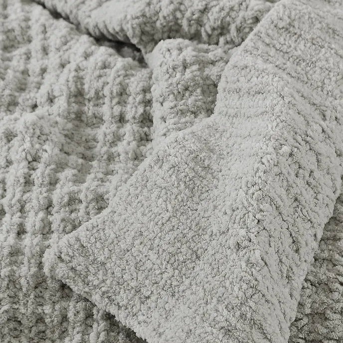 Soft gray textured blanket showcasing plush and cozy fabric close-up.