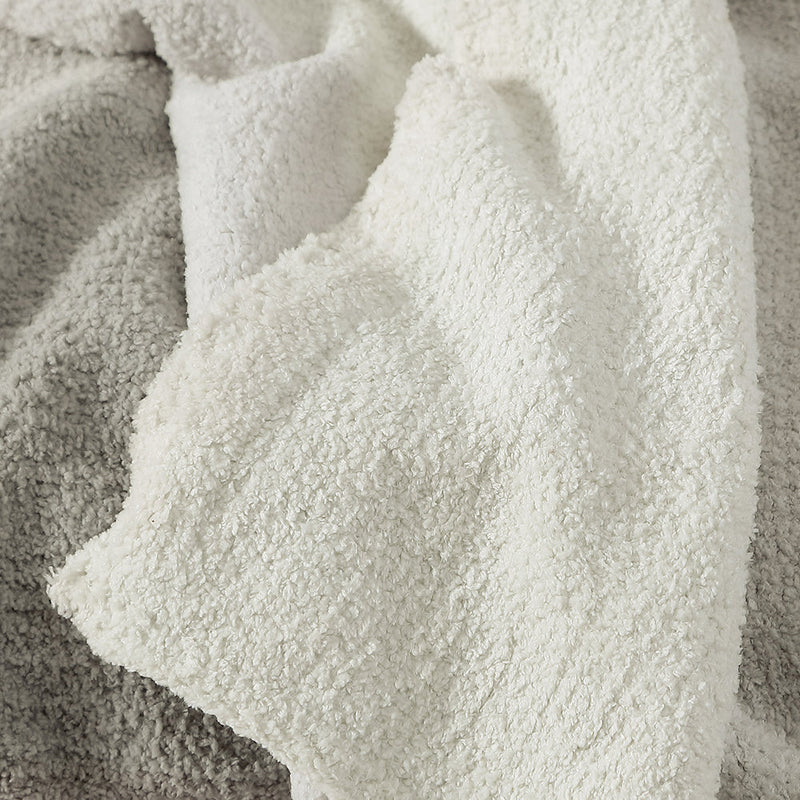 Soft and cozy textured blanket in cream and gray tones, perfect for home decor and comfort.