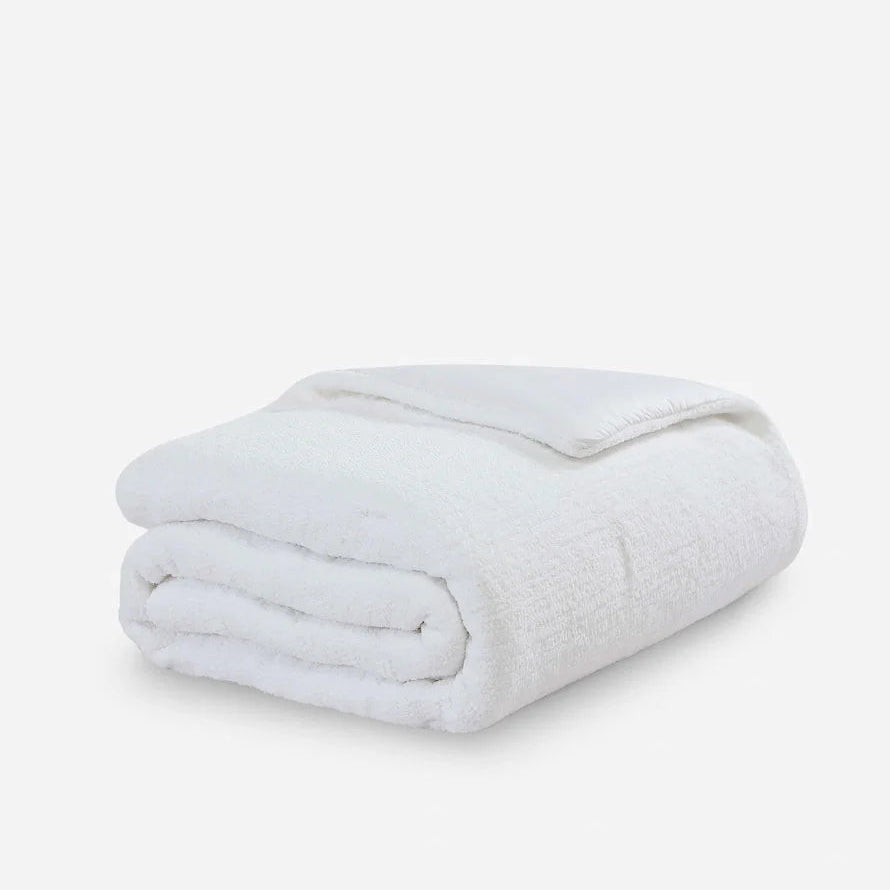 White plush towel folded neatly, providing luxurious comfort for bathroom or spa use.