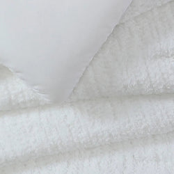 Plush white bedding set with soft pillows and luxurious texture.