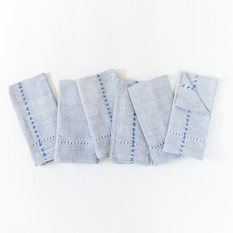 Elegant blue linen napkins with decorative stitching, perfect for dining table decoration and styling.