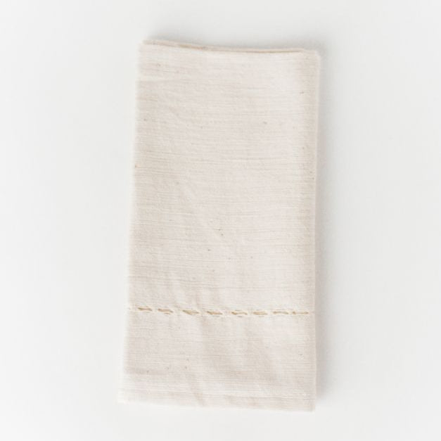 Handcrafted ivory cotton napkin with stitched detailing for elegant dining settings.
