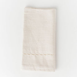Handcrafted ivory cotton napkin with stitched detailing for elegant dining settings.