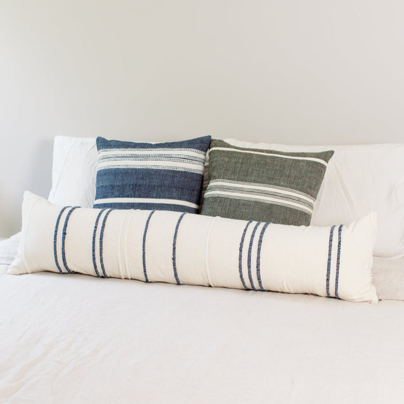 Decorative pillows on a bed with striped patterns for a cozy bedroom design.