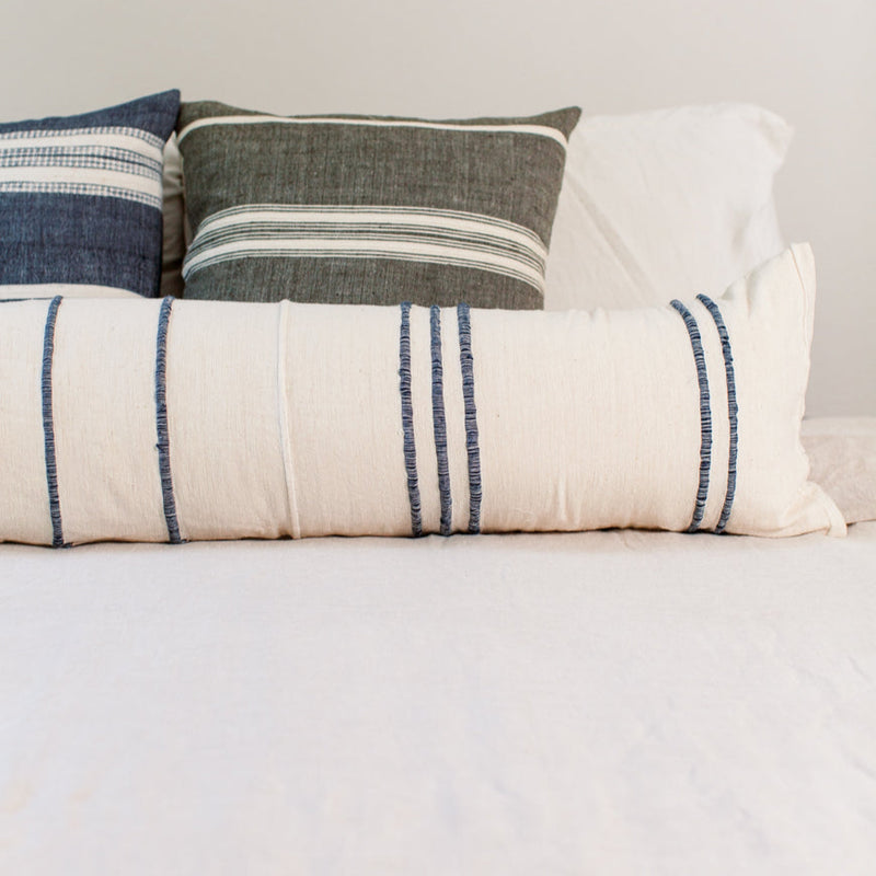 Decorative pillows on a bed with striped patterns for home decor.