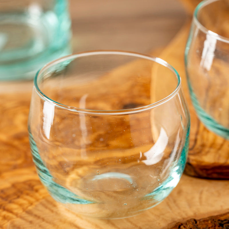Clear glass tumbler on wooden table, ideal for home dining and beverage displays.