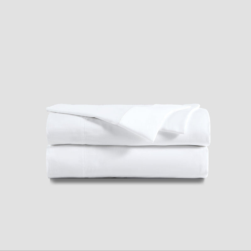 White cotton bedsheet set on a minimalist background - luxury bedding for comfortable sleep.