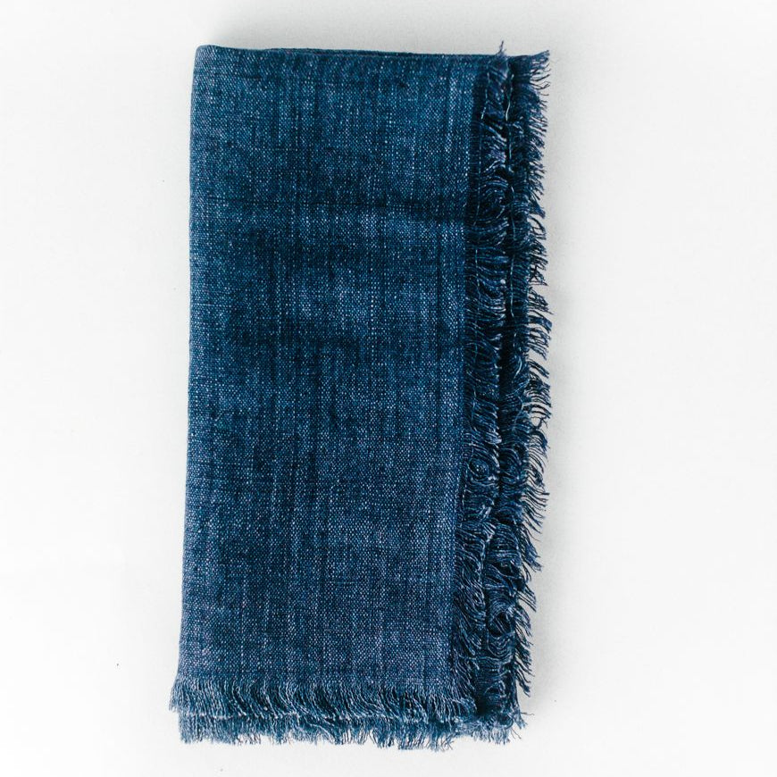 Folded blue denim fabric with frayed edges, ideal for crafting and fashion projects.