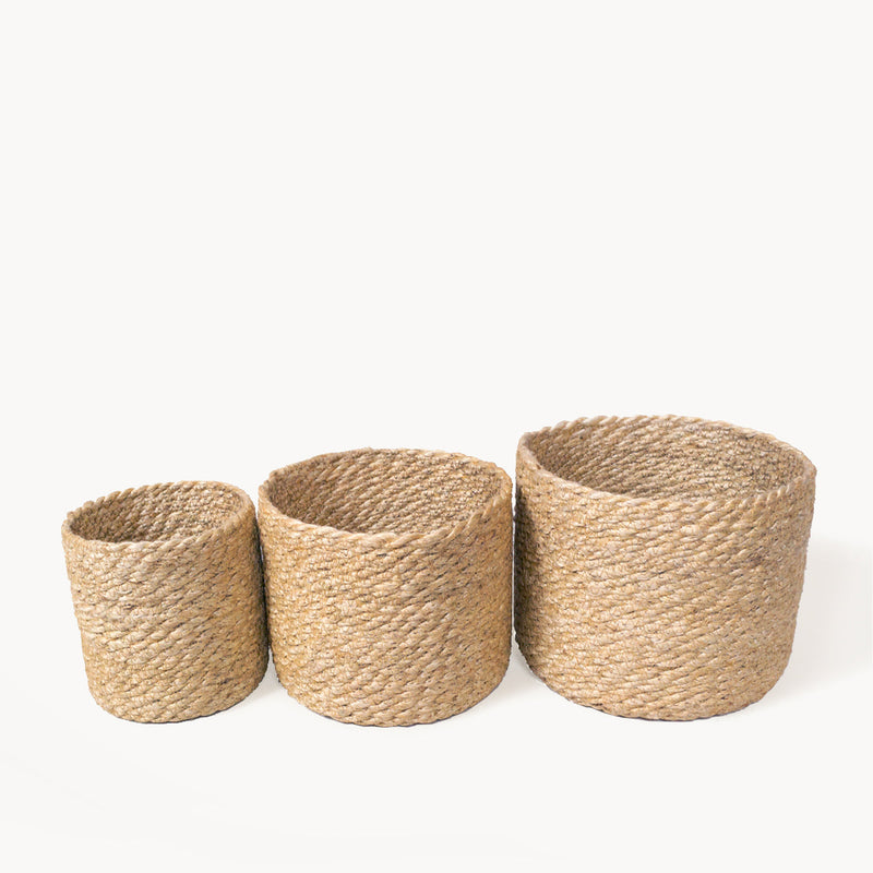 Set of three natural woven jute storage baskets in varying sizes.