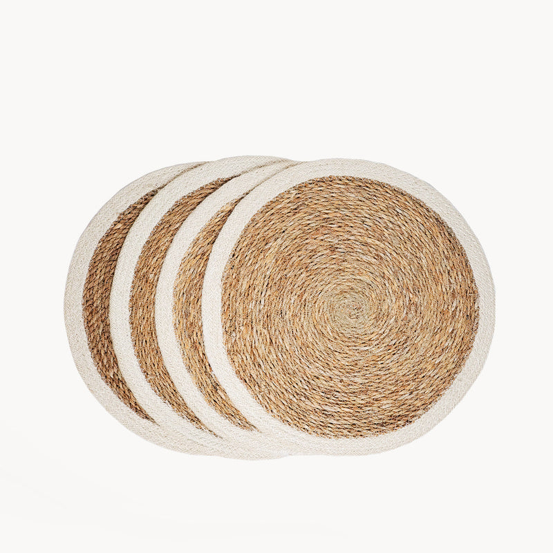 Set of four round natural woven placemats with a rustic design.