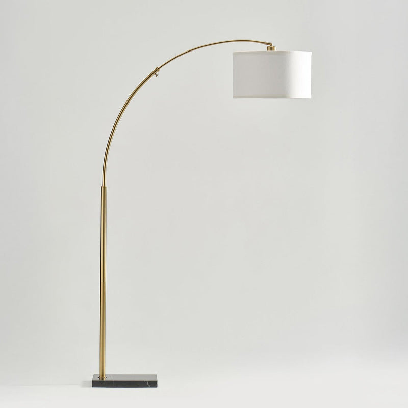 Elegant modern floor lamp with curved gold stand and white shade on marble base.