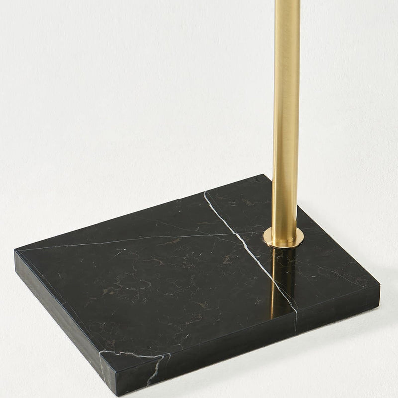 Black marble base with brass pole detail for modern floor lamp design.