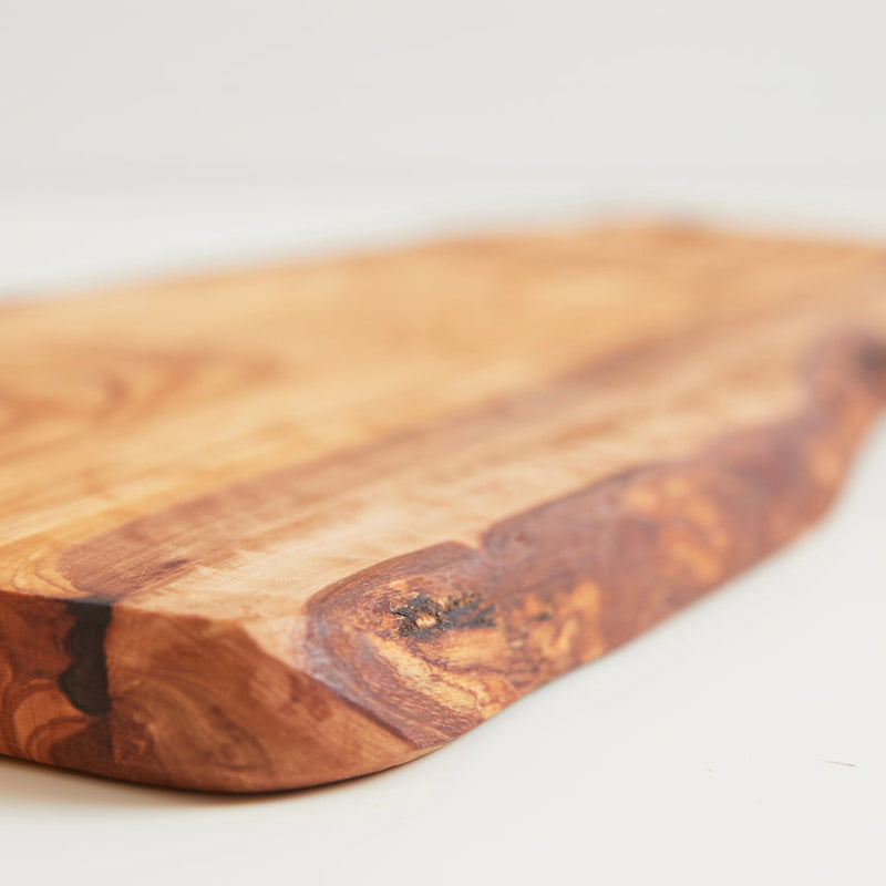 Rustic wooden cutting board with a natural edge and smooth texture.