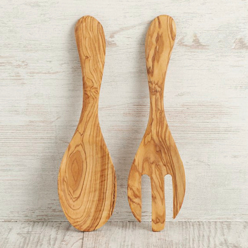 Pair of handcrafted wooden salad spoons on rustic white background.