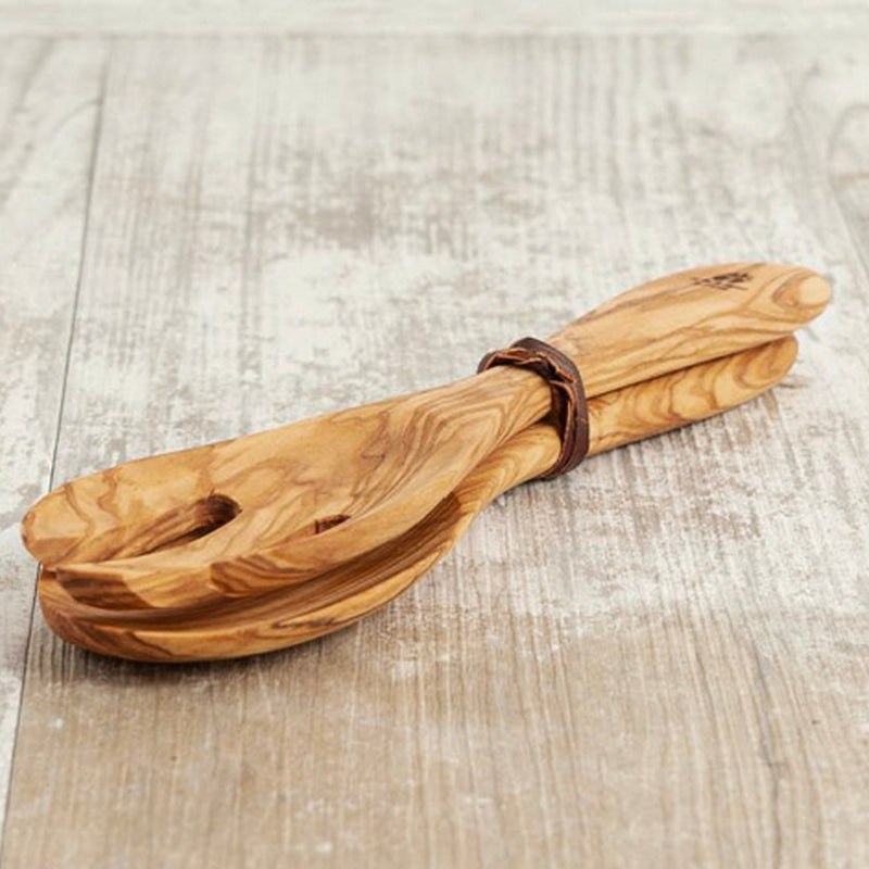 Handcrafted wooden kitchen utensils on rustic wooden table.