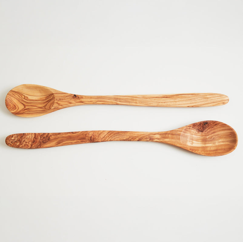 Handcrafted olive wood spoons on white background, ideal for eco-friendly cooking and kitchen decor.