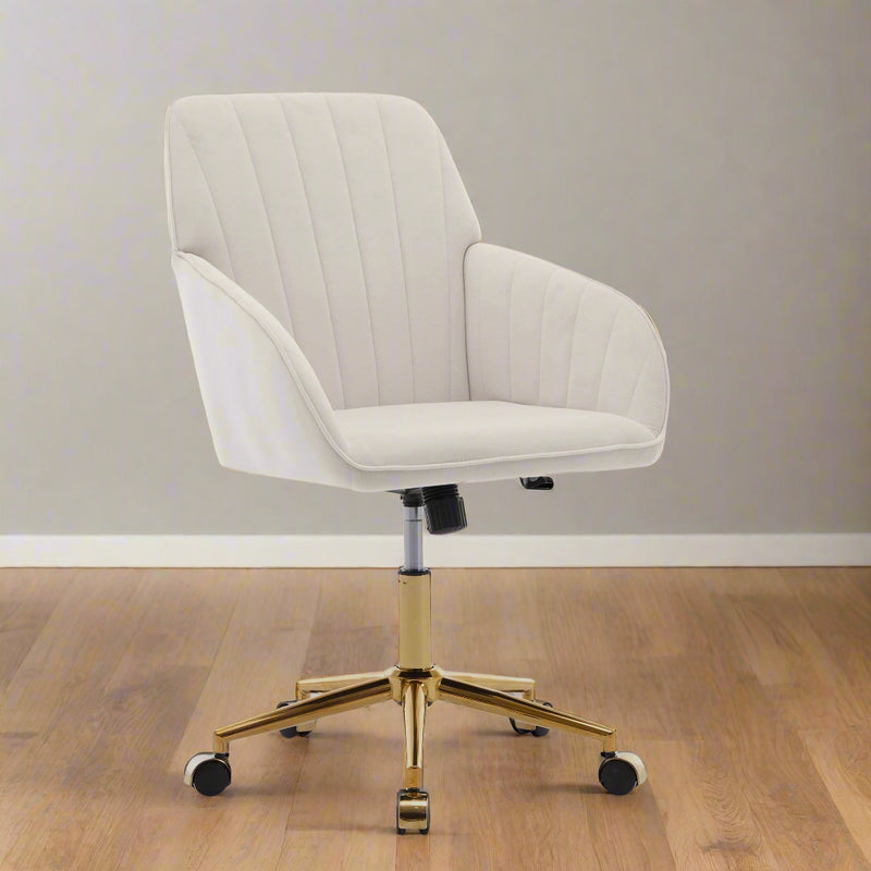 Office swivel chair with white upholstery and gold base in modern workspace.