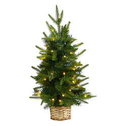 Tabletop artificial Christmas tree with warm white LED string lights in woven wicker basket, festive holiday home and office decor